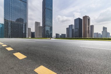 Panoramik siluet ve boş yolu, boş beton zemini olan modern iş binaları.