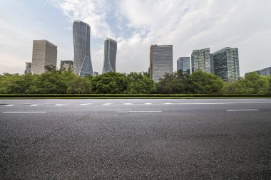 Panoramik siluet ve boş yolu, boş beton zemini olan modern iş binaları.