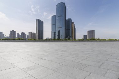Panoramik siluet ve boş yolu, boş beton zemini olan modern iş binaları.