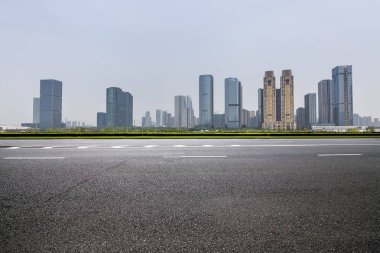 Panoramik siluet ve boş yolu, boş beton zemini olan modern iş binaları.