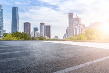 Panoramik siluet ve boş yolu, boş beton zemini olan modern iş binaları.