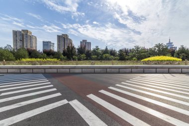 Panoramik siluet ve boş yolu, boş beton zemini olan modern iş binaları.