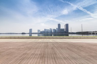 Panoramik siluet ve boş yolu, boş beton zemini olan modern iş binaları.