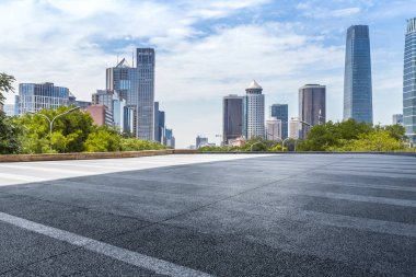 Panoramik siluet ve boş yolu, boş beton zemini olan modern iş binaları.