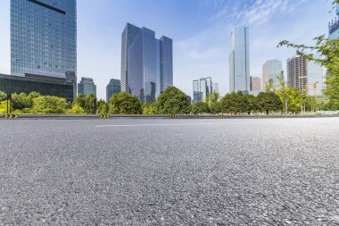 Panoramik siluet ve boş yolu, boş beton zemini olan modern iş binaları.