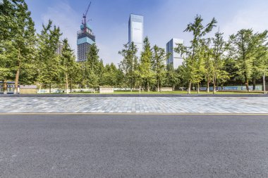 Panoramik siluet ve boş yolu, boş beton zemini olan modern iş binaları.