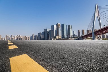 Panoramik siluet ve boş yolu, boş beton zemini olan modern iş binaları.