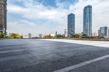 Panoramik siluet ve boş yolu, boş beton zemini olan modern iş binaları.