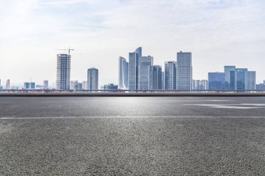 Panoramik siluet ve boş yolu, boş beton zemini olan modern iş binaları.