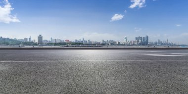 Panoramik siluet ve boş yolu, boş beton zemini olan modern iş binaları.