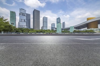 Panoramik siluet ve boş yolu, boş beton zemini olan modern iş binaları.