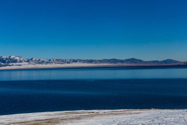  Kar dağ arka plan yılı, Çin Xinjiang, donmuş Sailimu Gölü