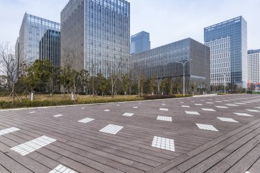 Panoramik siluet ve boş yolu, boş beton zemini olan modern iş binaları.