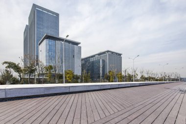 Panoramik siluet ve boş yolu, boş beton zemini olan modern iş binaları.