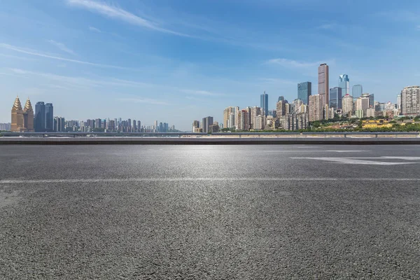 Panoramik siluet ve boş yolu, boş beton zemini olan modern iş binaları.