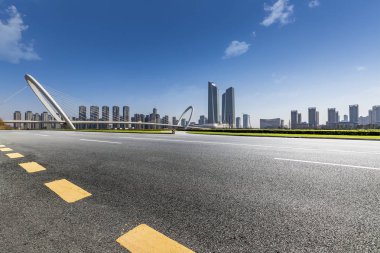 Panoramik siluet ve boş yolu, boş beton zemini olan modern iş binaları.