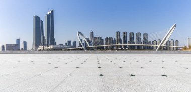 Panoramik siluet ve boş yolu, boş beton zemini olan modern iş binaları.