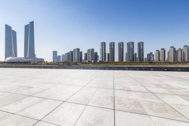 Panoramik siluet ve boş yolu, boş beton zemini olan modern iş binaları.