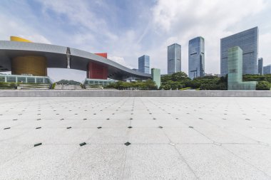 Panoramik siluet ve boş yolu, boş beton zemini olan modern iş binaları.