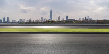 Panoramik siluet ve boş yolu, boş beton zemini olan modern iş binaları.