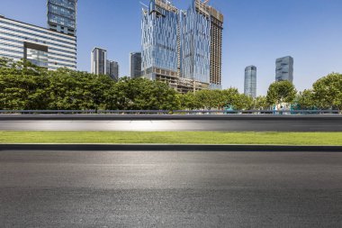 Panoramik siluet ve boş yolu, boş beton zemini olan modern iş binaları.