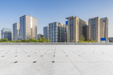 Panoramik siluet ve boş yolu, boş beton zemini olan modern iş binaları.
