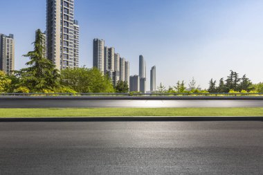 Panoramik siluet ve boş yolu, boş beton zemini olan modern iş binaları.