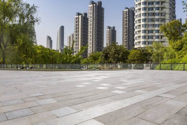 Panoramik siluet ve boş yolu, boş beton zemini olan modern iş binaları.