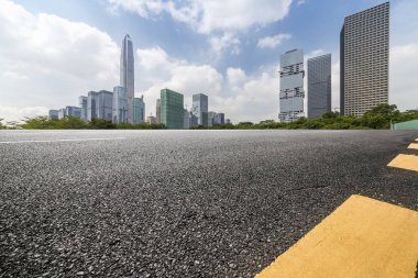 Panoramik siluet ve boş yolu, boş beton zemini olan modern iş binaları.