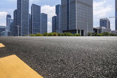 Panoramik siluet ve boş yolu, boş beton zemini olan modern iş binaları.