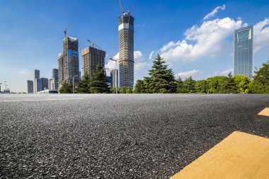 Panoramik siluet ve boş yolu, boş beton zemini olan modern iş binaları.
