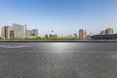 Panoramik siluet ve boş yolu, boş beton zemini olan modern iş binaları.