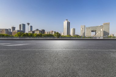 Panoramik siluet ve boş yolu, boş beton zemini olan modern iş binaları.