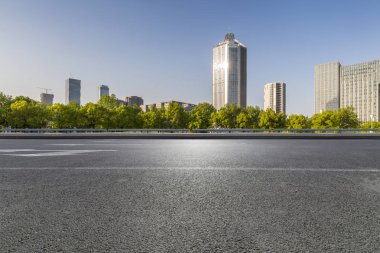 Panoramik siluet ve boş yolu, boş beton zemini olan modern iş binaları.