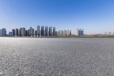 Panoramik siluet ve boş yolu, boş beton zemini olan modern iş binaları.