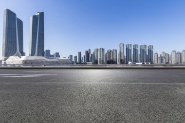 Panoramik siluet ve boş yolu, boş beton zemini olan modern iş binaları.
