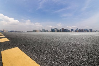 Panoramik siluet ve boş yolu, boş beton zemini olan modern iş binaları.