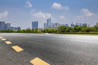 Panoramik siluet ve boş yolu, boş beton zemini olan modern iş binaları.
