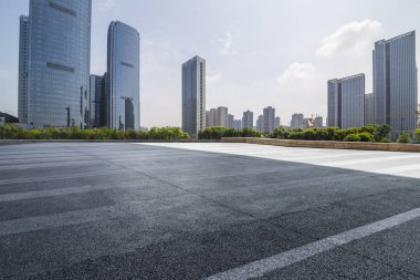 Panoramik siluet ve boş yolu, boş beton zemini olan modern iş binaları.