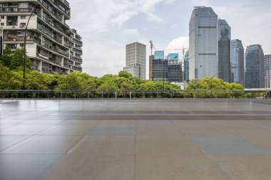 Panoramik siluet ve boş yolu, boş beton zemini olan modern iş binaları.