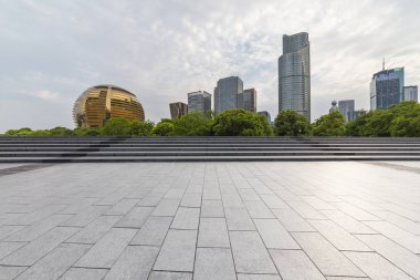 Panoramik siluet ve boş yolu, boş beton zemini olan modern iş binaları.