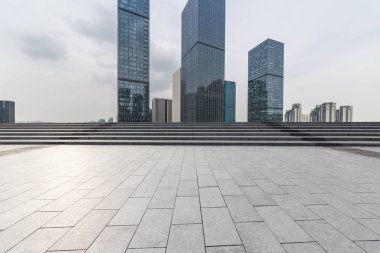 Panoramik siluet ve boş yolu, boş beton zemini olan modern iş binaları.