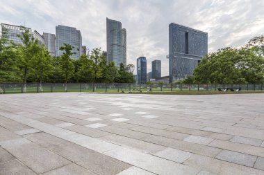 Panoramik siluet ve boş yolu, boş beton zemini olan modern iş binaları.