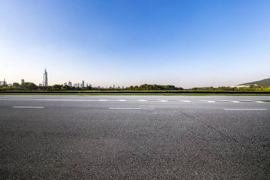 Panoramik siluet ve boş yolu, boş beton zemini olan modern iş binaları.