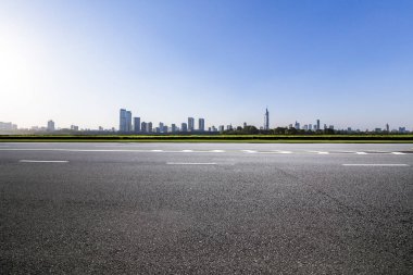 Panoramik siluet ve boş yolu, boş beton zemini olan modern iş binaları.