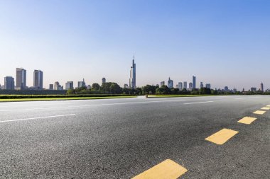 Panoramik siluet ve boş yolu, boş beton zemini olan modern iş binaları.