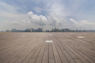 Panoramik siluet ve boş yolu, boş beton zemini olan modern iş binaları.