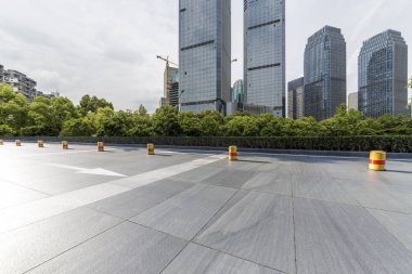 Panoramik siluet ve boş yolu, boş beton zemini olan modern iş binaları.