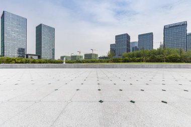 Panoramik siluet ve boş yolu, boş beton zemini olan modern iş binaları.