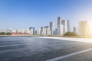 Panoramik siluet ve boş yolu, boş beton zemini olan modern iş binaları.